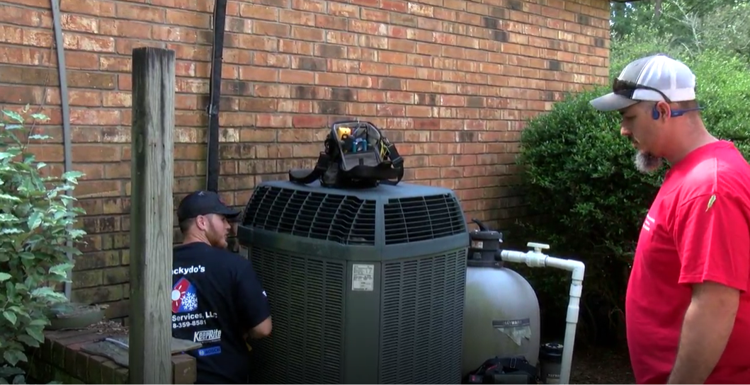 image of an air conditioning repair person maintaining an AC unit
